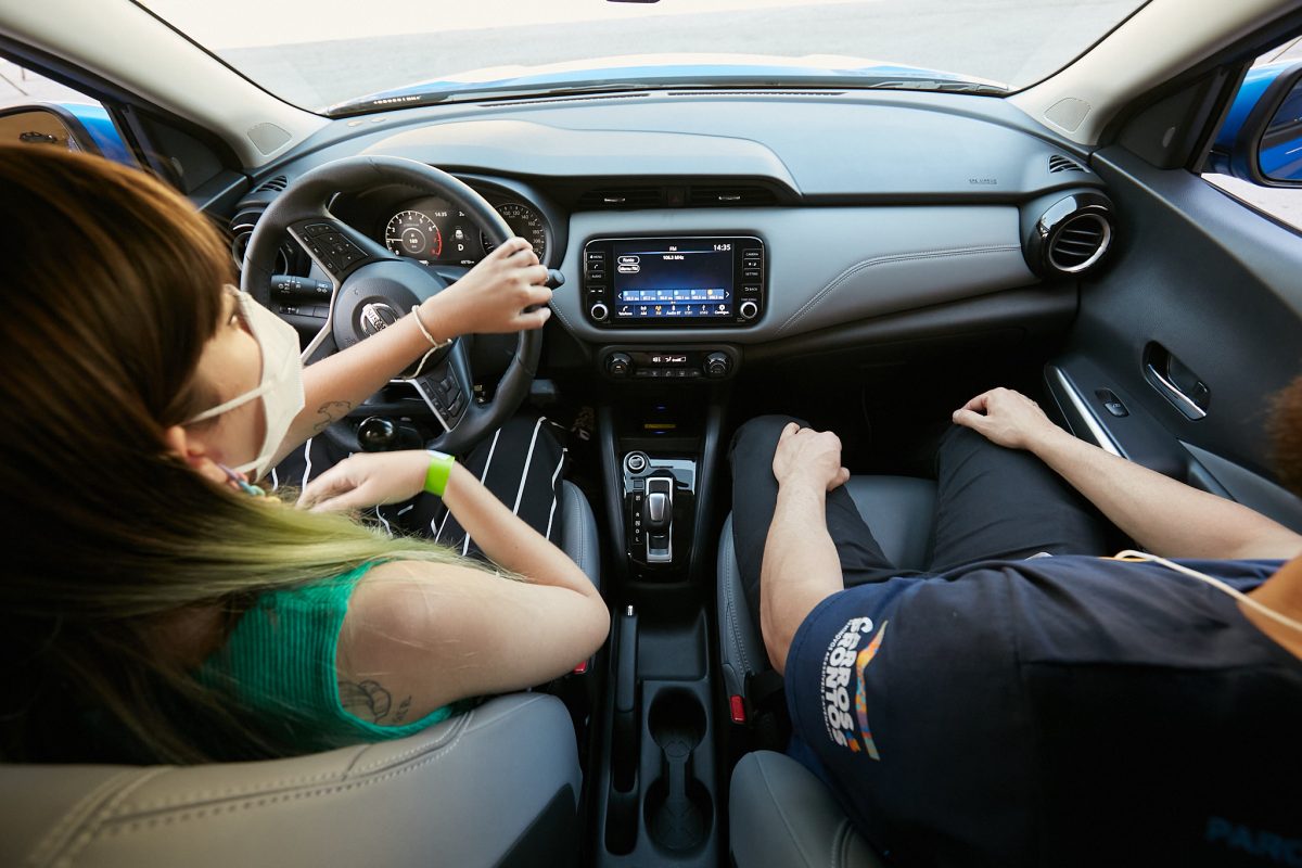 Mulher fazendo o Test-Drive com um Nissan Kick na Reatech 2022